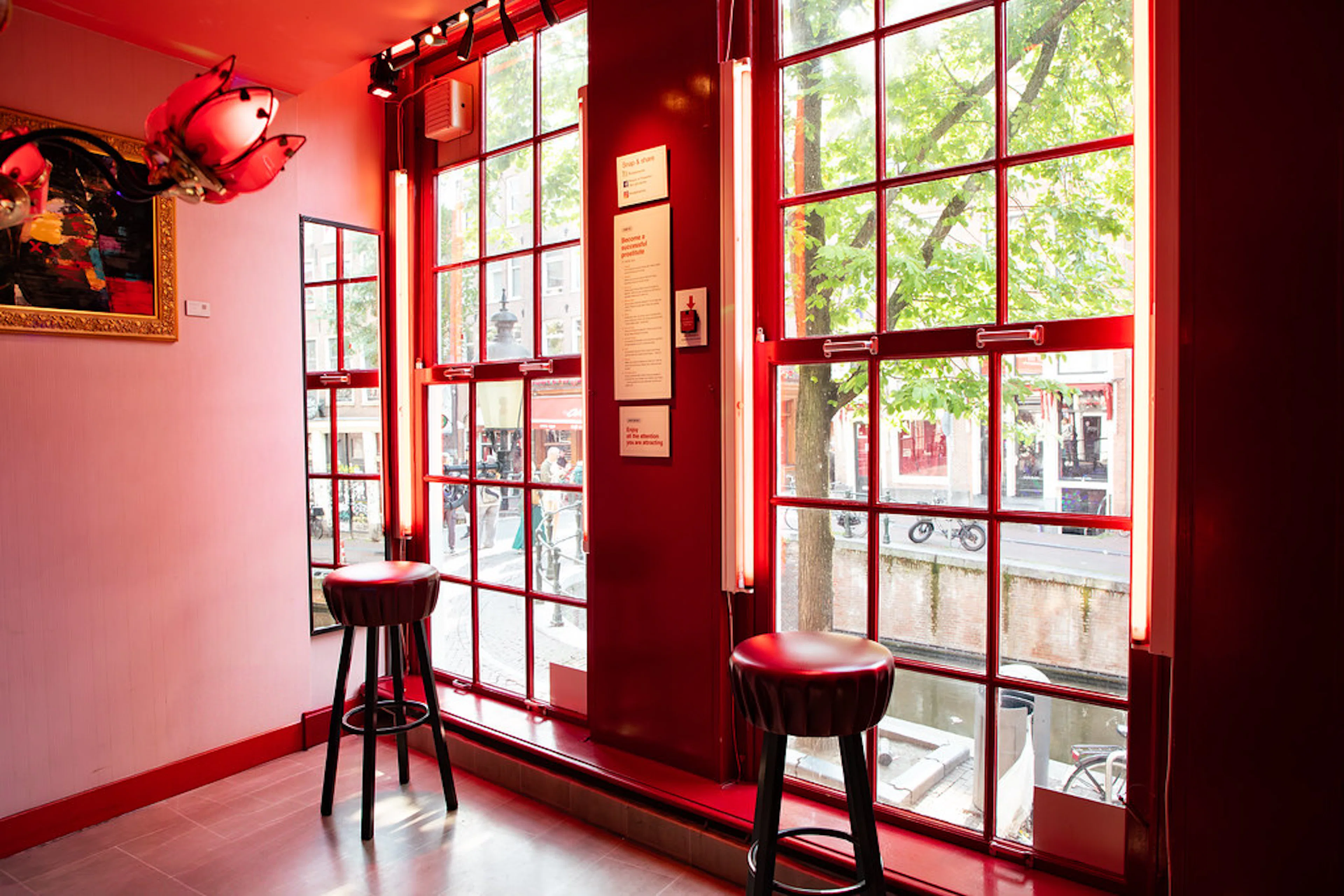 Red Light Secrets Museum interior with red-lit windows overlooking Amsterdam canal.