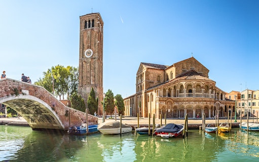 Murano's Basilica dei Santi Maria e Donato with boats on the canal, Venice tour.
