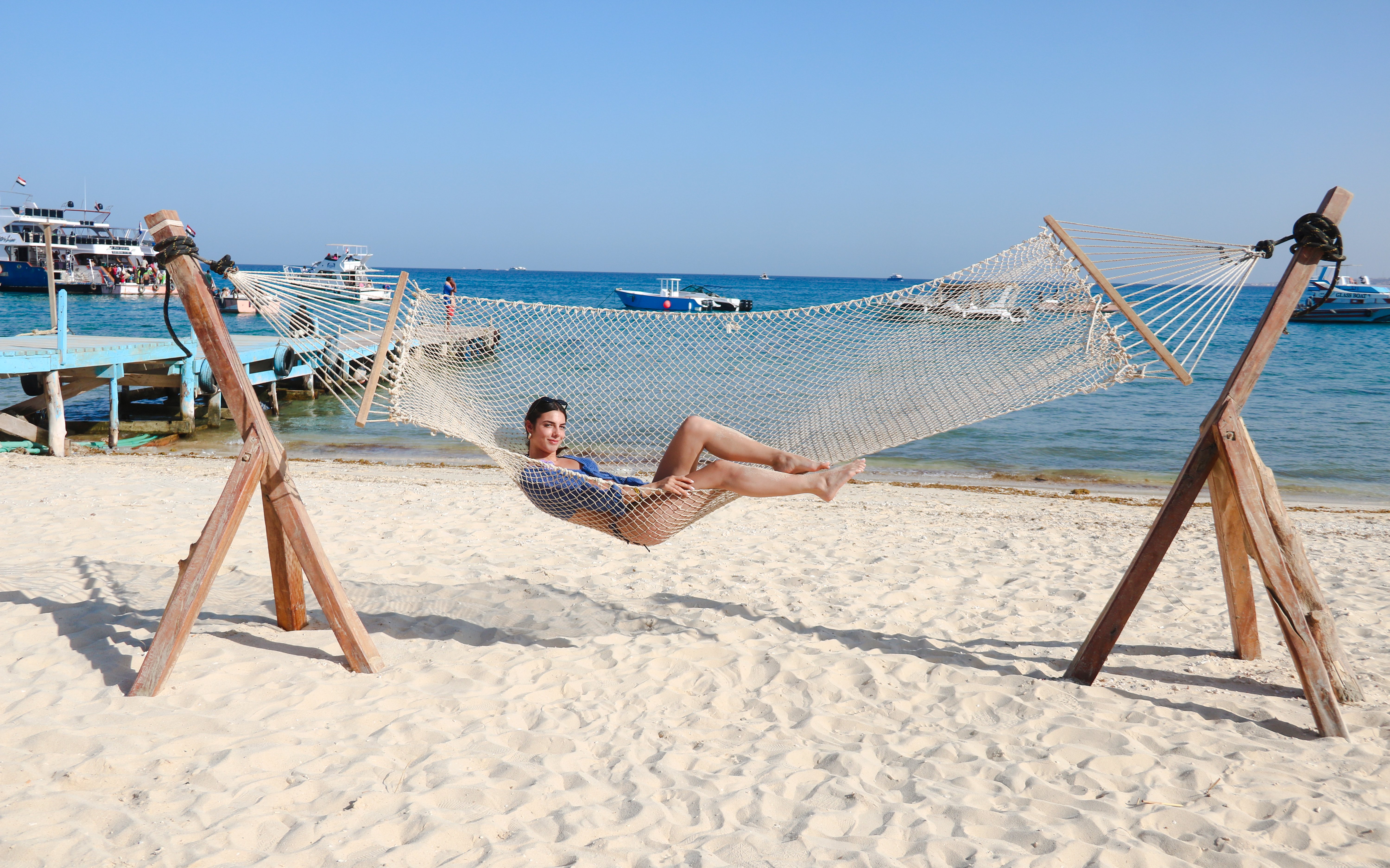 Person relaxing in a hammock on a sandy beach during Giftun 3 Islands Tour.