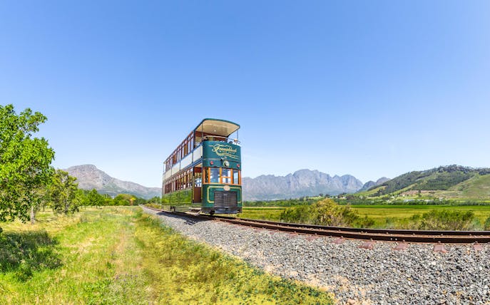 Tram on tracks through vineyards, Franschhoek Wine Tram Xplorer Tour, Cape Town.