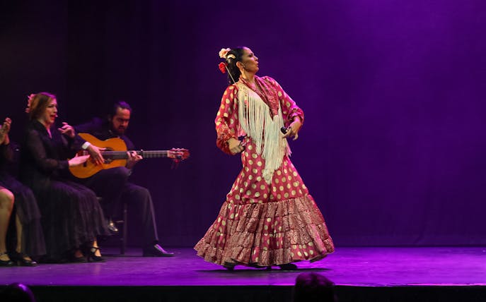 Flamenco dancer performing on stage with guitarist and singer, Emociones - Espectáculo flamenco.