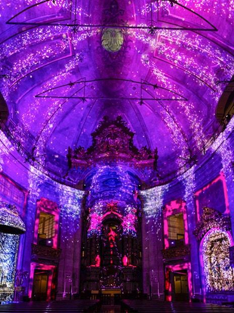 Clérigos Church interior with vibrant purple light display during Spiritus event.