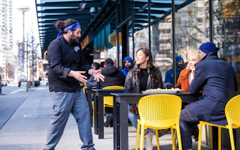Chef engaging with diners on a street food tour in South Lake Union, Seattle.