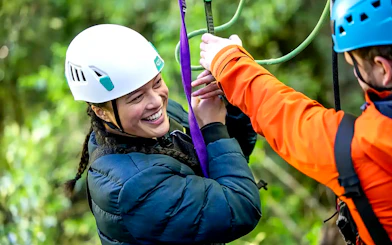 Person enjoying a zipline experience in Rotorua Forest.