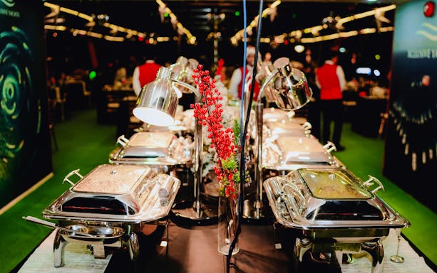 Buffet setup on a Christmas dinner cruise with festive decorations and chafing dishes.