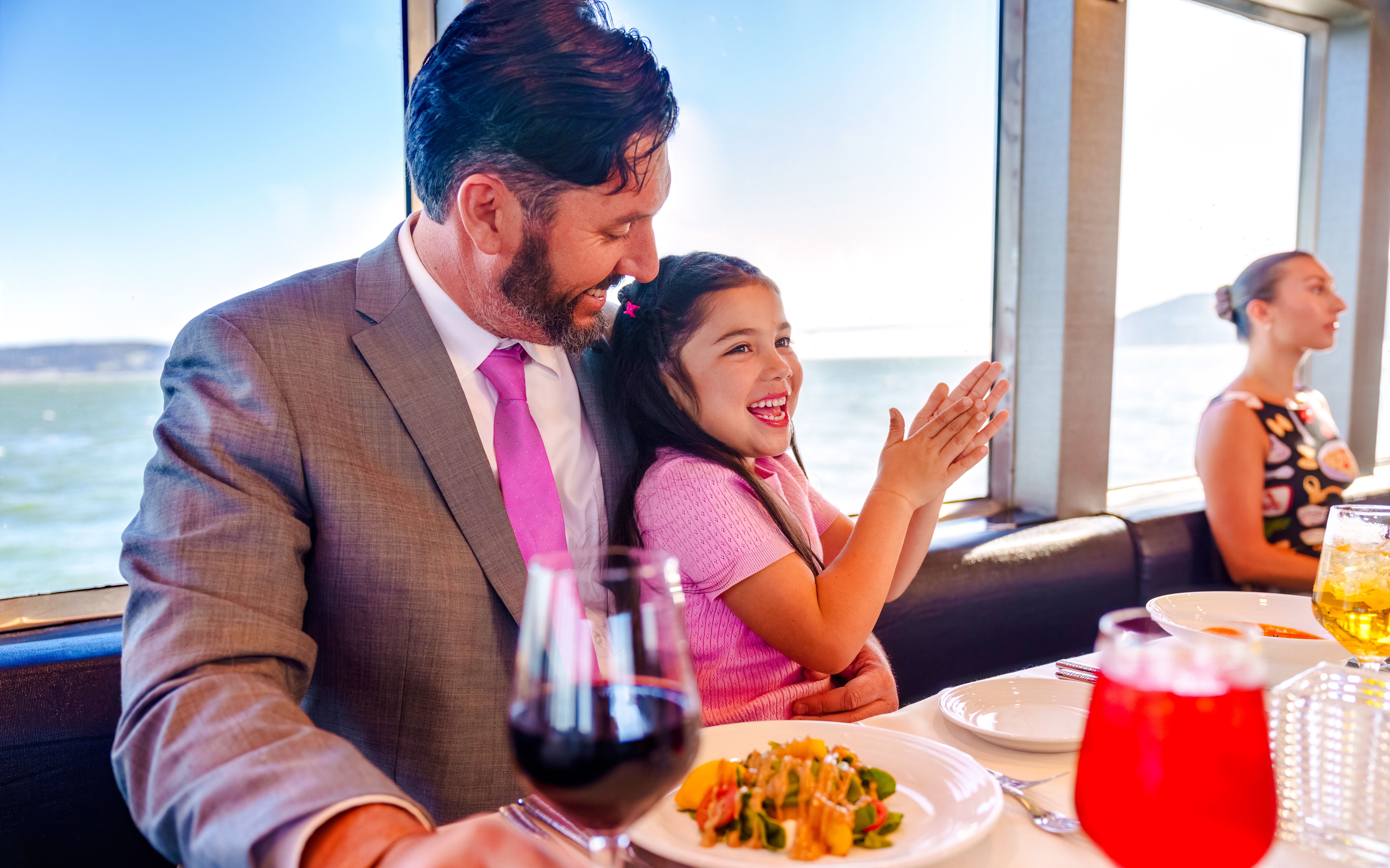Father and daughter enjoying a meal on a San Francisco dinner cruise.