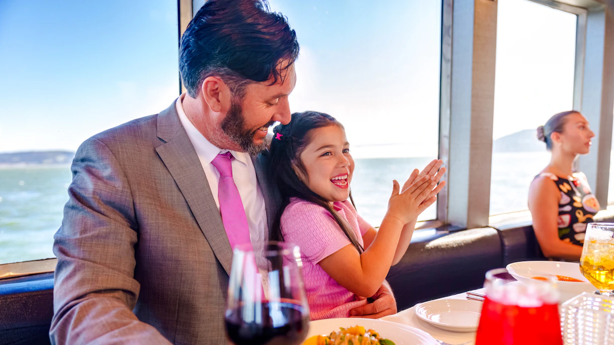 Father and daughter enjoying a meal on a San Francisco dinner cruise.