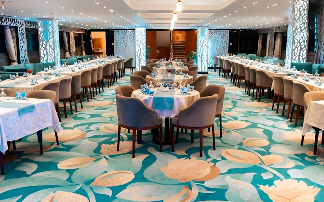 Elegant dining setup on a Nile dinner cruise in Cairo with decorated tables and chairs.