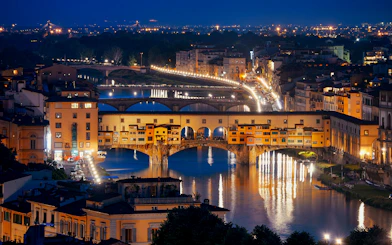 Ponte Vecchio illuminated at night over the Arno River in Florence, Italy.