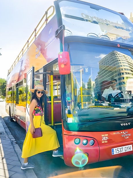 Woman boarding City Sightseeing hop-on hop-off bus at Plaza de la Marina, Malaga.