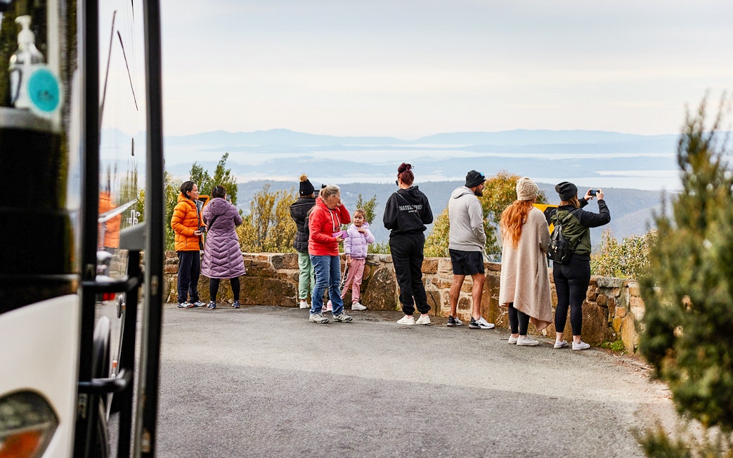 Tour group enjoying scenic view from Mt Wellington lookout, Tasmania.