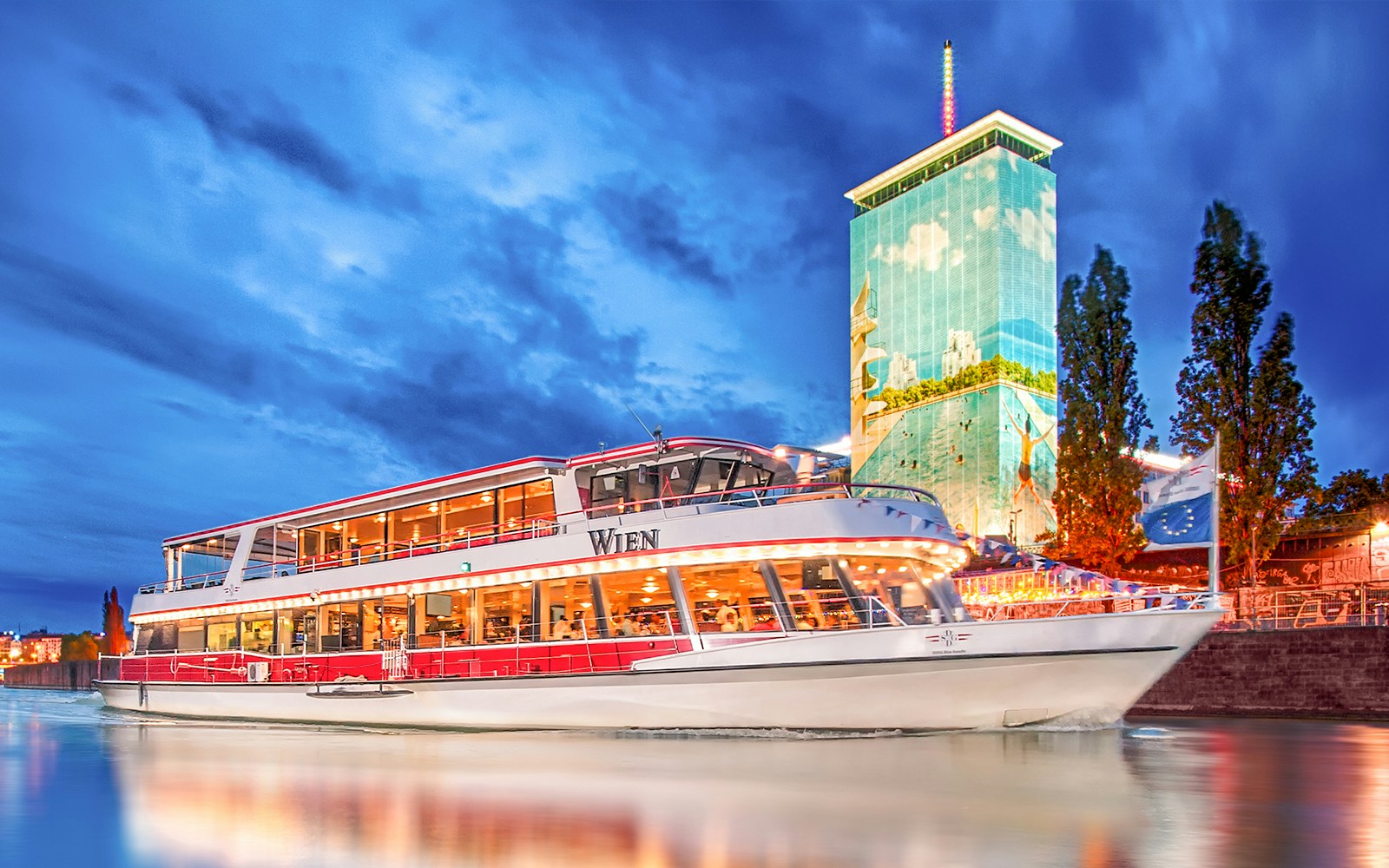 DDSG Blue Danube cruise ship on the Danube River, Vienna, with Ringturm building.
