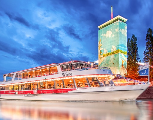 DDSG Blue Danube cruise ship on the Danube River, Vienna, with Ringturm building.