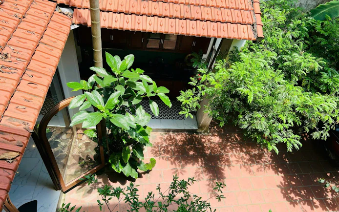 Courtyard view of a traditional Vietnamese cooking class venue with lush greenery.