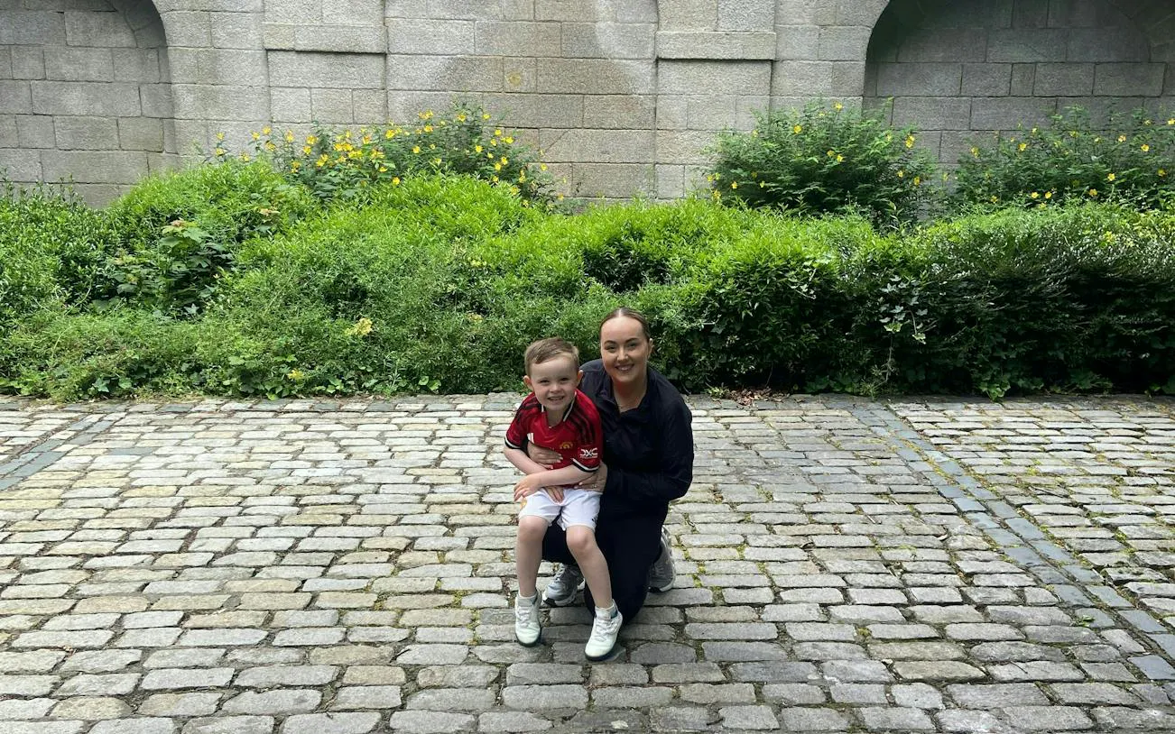 Child and adult on cobblestone path in Dublin garden, part of Kid Quest Lost Senses game.