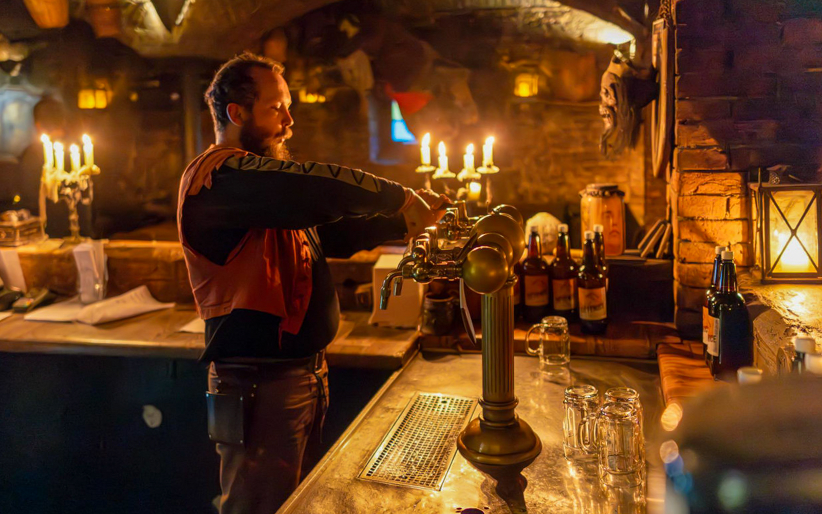 Bartender serving beer at Dětenice Brewery during medieval dinner show near Prague.