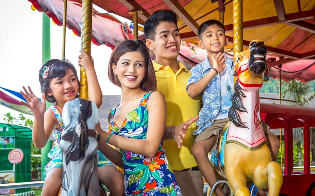 Family enjoying carousel ride at Sunway Lost World of Tambun, Malaysia.