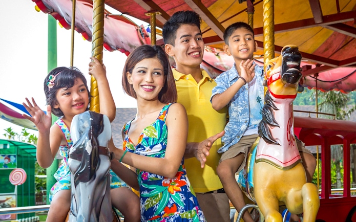 Family enjoying carousel ride at Sunway Lost World of Tambun, Malaysia.