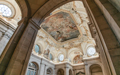 Ceiling fresco and ornate architecture inside the Royal Palace of Madrid.