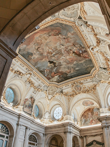 Ceiling fresco and ornate architecture inside the Royal Palace of Madrid.