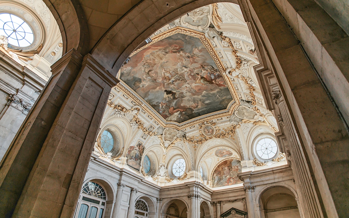 Ceiling fresco and ornate architecture inside the Royal Palace of Madrid.