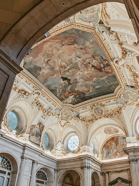 Ceiling fresco and ornate architecture inside the Royal Palace of Madrid.