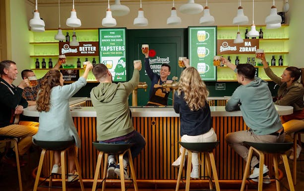 Group enjoying beer tasting at Pilsner Urquell bar in Prague.