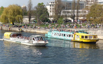 Berlin sightseeing cruise on the Spree River with boats and riverside park.