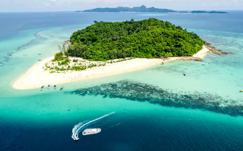Aerial view of Bamboo Island with lush greenery and sandy beaches, Phuket catamaran tour.
