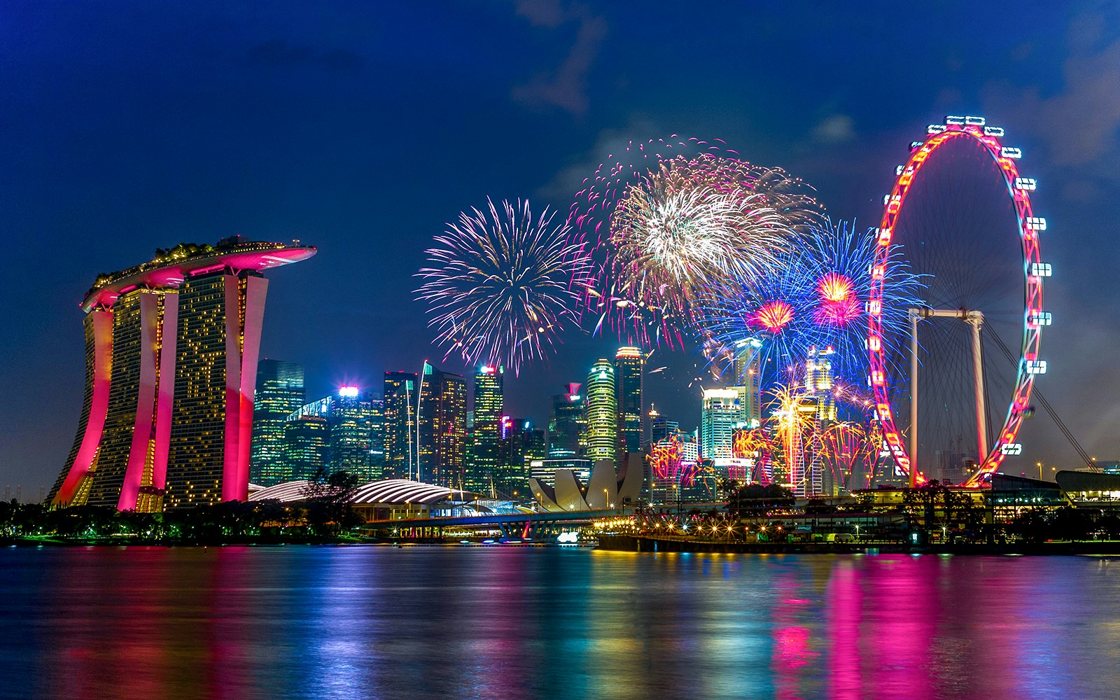 Singapore Flyer and city skyline with New Year's Eve fireworks.