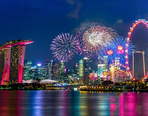 Singapore Flyer and city skyline with New Year's Eve fireworks display.