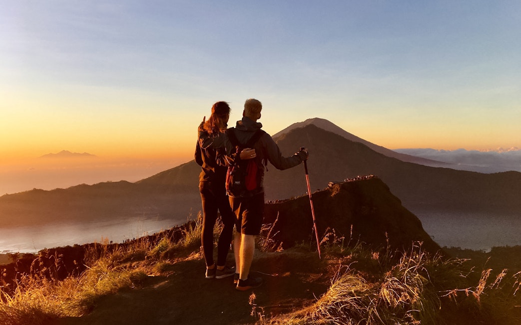 Couple admiring Mount Batur during a sunrise trek in Bali.