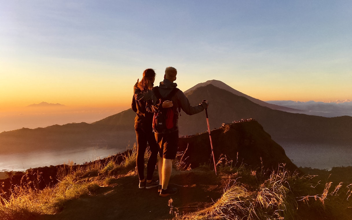 Couple admiring Mount Batur during a sunrise trek in Bali.