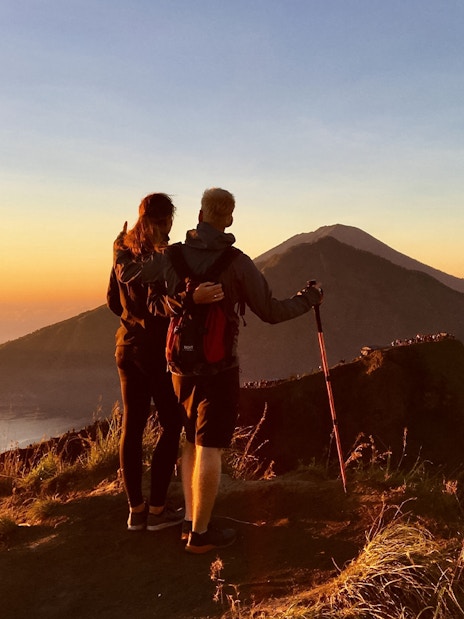 Couple admiring Mount Batur during a sunrise trek in Bali.