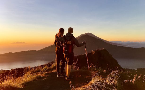 Couple admiring Mount Batur during a sunrise trek in Bali.