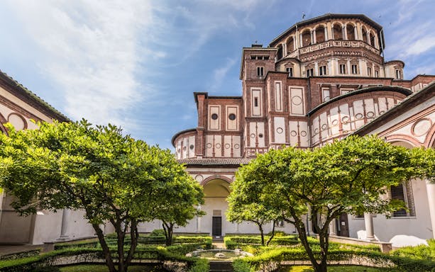 Courtyard with lush garden and historic architecture in Rome, Italy.