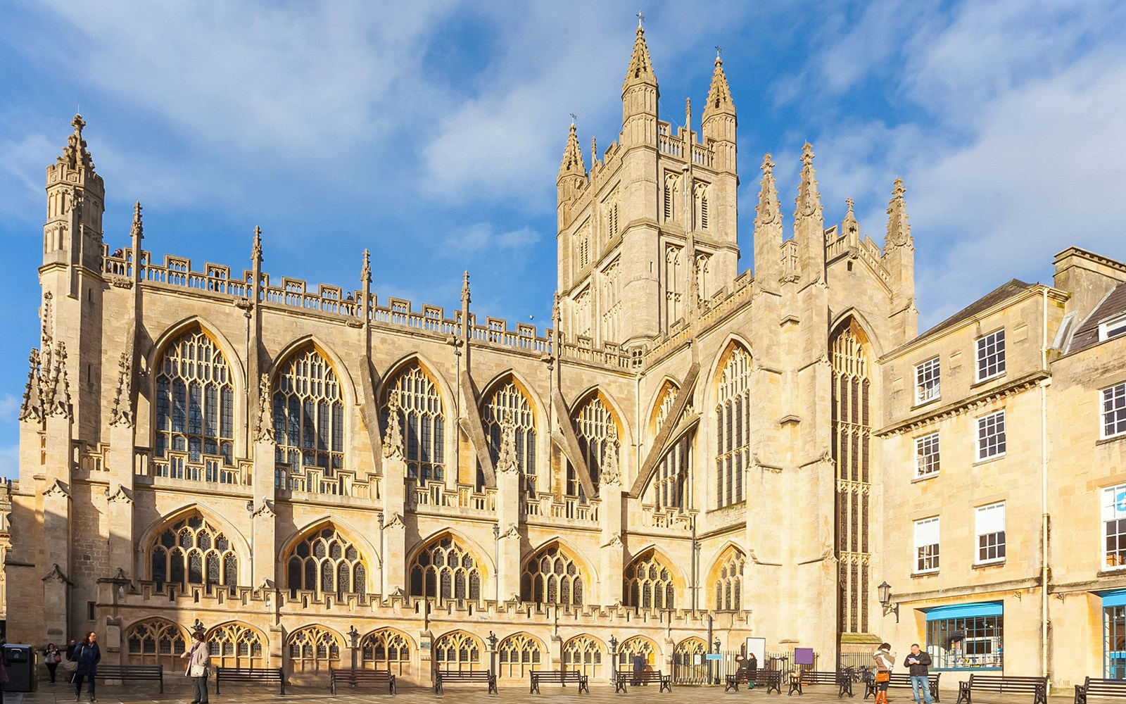 Bath Abbey's Gothic architecture in Bath, England, with visitors outside.