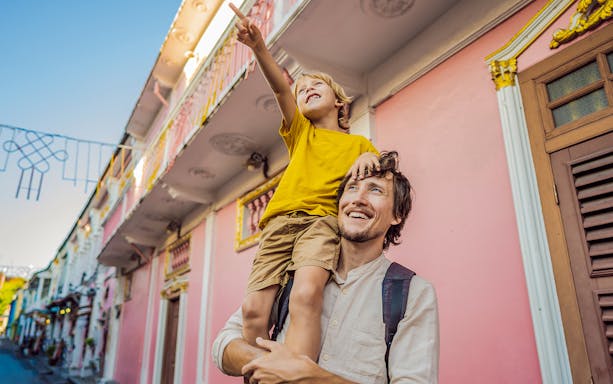 Father and child exploring colorful streets in Phuket's Old Town.