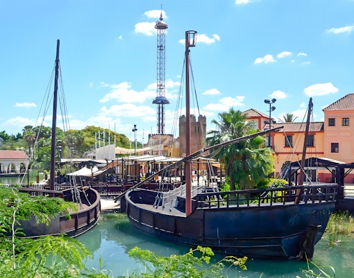 Sevilla's Puerto de Indias at Isla Magica theme park with vibrant water features.