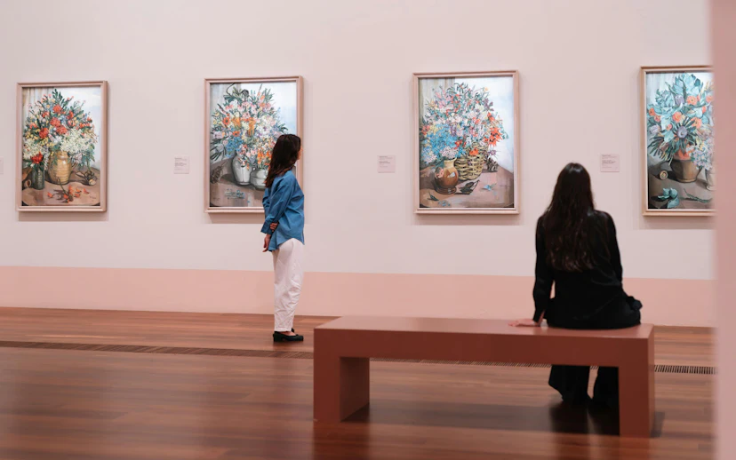 Visitors viewing Margaret Preston paintings at the National Gallery of Victoria exhibition.