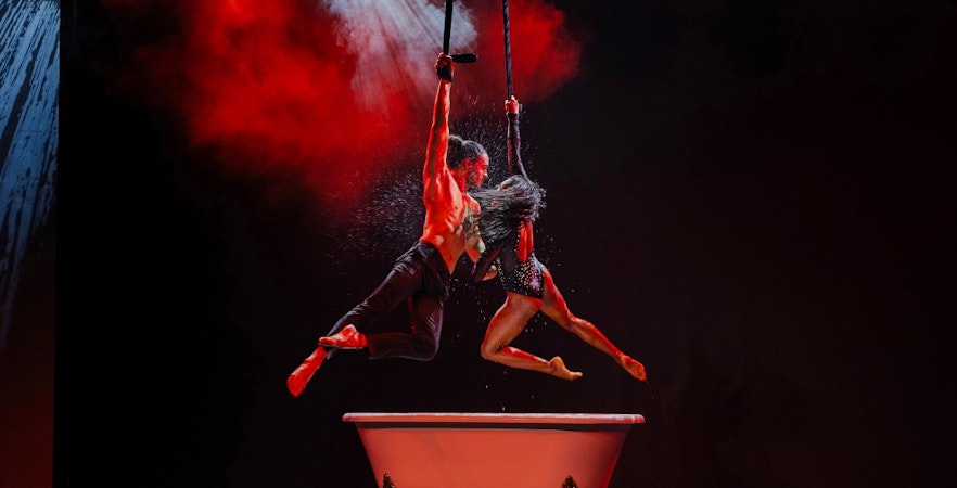 Acrobats performing above a bathtub at Paris Paradis show.