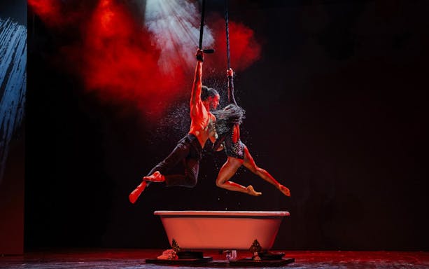 Acrobats performing above a bathtub at Paris Paradis show.