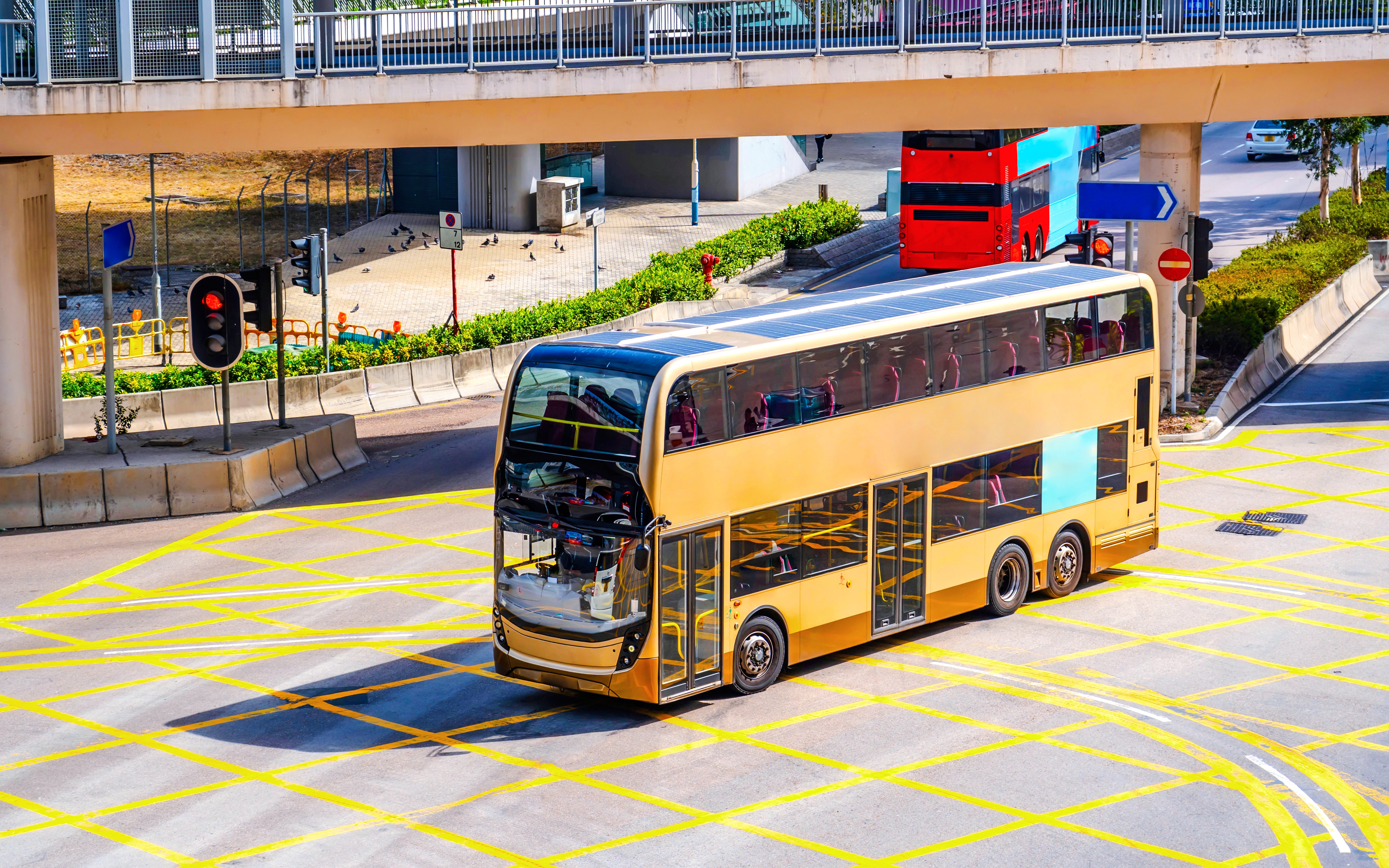 Double-decker bus at a Hong Kong intersection, aerial view.