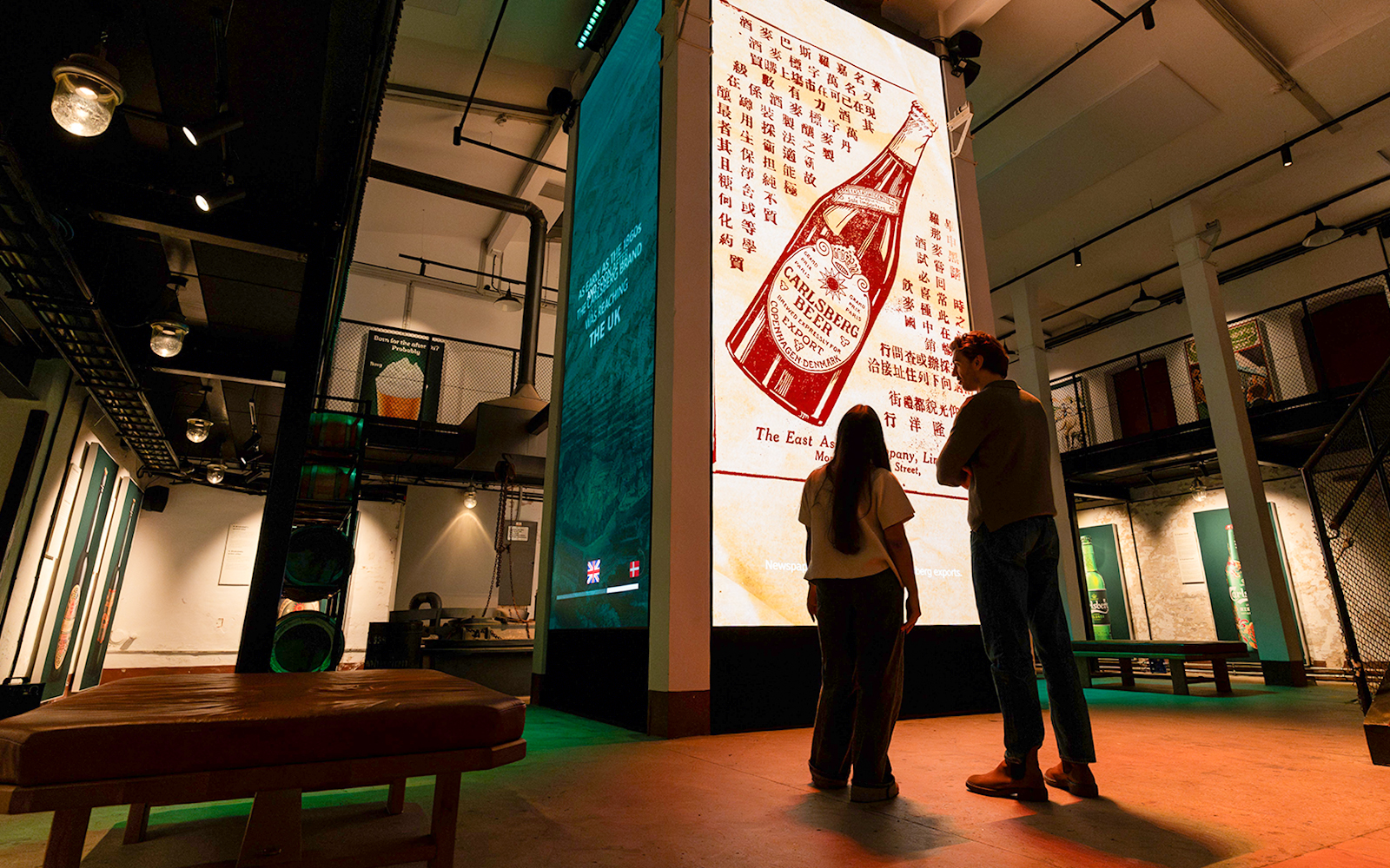 Visitors viewing Carlsberg beer exhibit inside Home of Carlsberg museum.