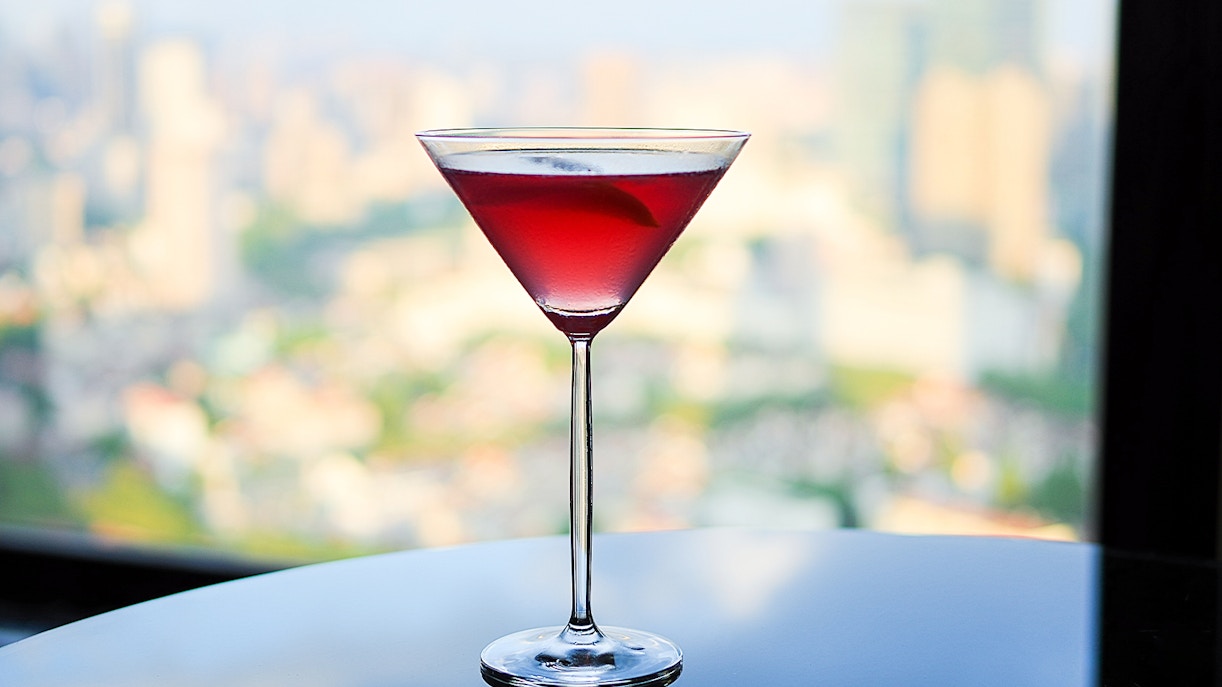 Cocktail on a table at Bar 94 with city skyline view.