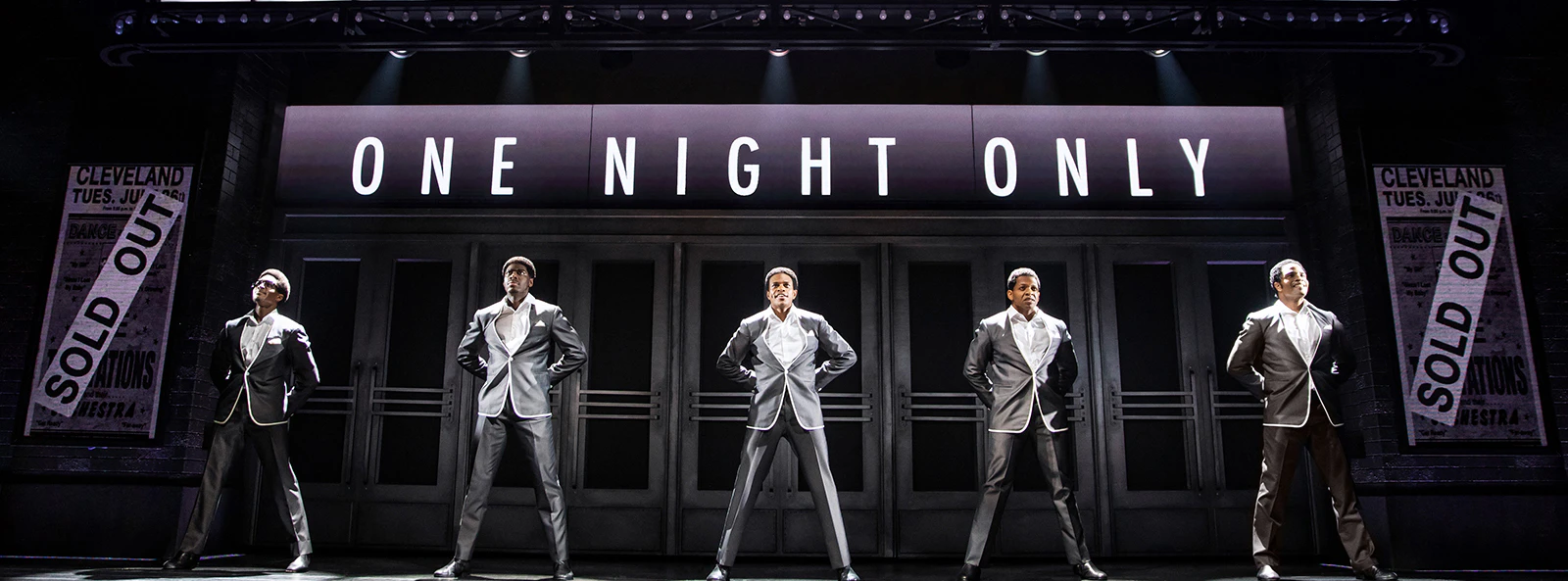 The Temptations musical performance, Ain't Too Proud, on stage with marquee sign.