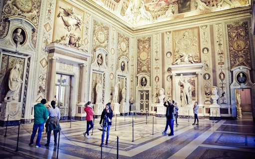 Visitors exploring art and sculptures inside Borghese Gallery, Rome.