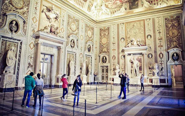 Visitors exploring art and sculptures inside Borghese Gallery, Rome.