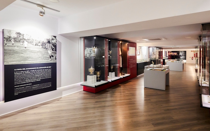 Sevilla FC History Experience museum interior with trophies and historical displays.