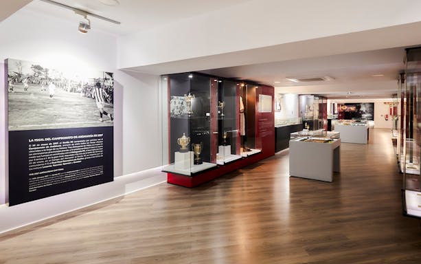 Sevilla FC History Experience museum interior with trophies and historical displays.